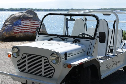 Moke electric vehicle parked out front of a beach